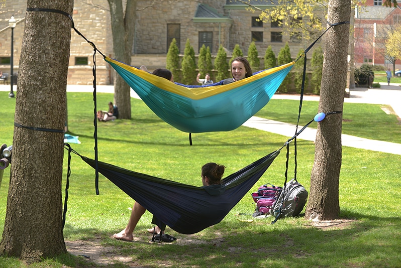 Hope College students laying in hammocks, one hammock installed above the other