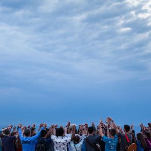 A group of students praying on the beach