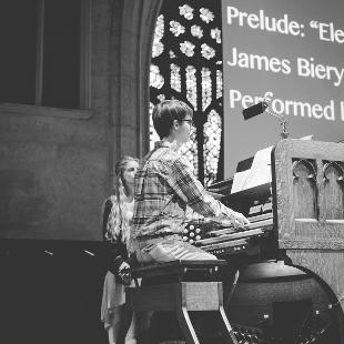 An Awakening student playing the keyboard