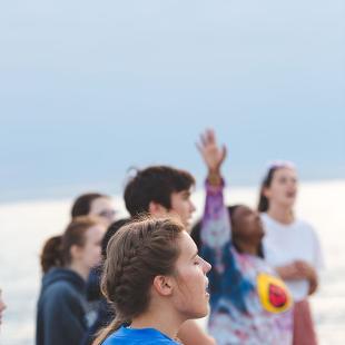 Students worshiping on the beach