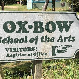 一块牌子上写着“Ox-Bow艺术学院”和“游客!在办公室注册”指向的手