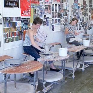 A crowd of people milling among artwork on display