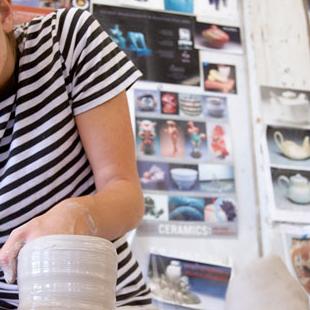 A student creating on a pottery wheel