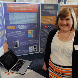 A student stands in front of a tri-fold poster during Celebration