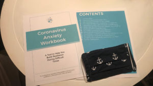 The cover and table of contents pages of the workbook are printed out and lying on a table.